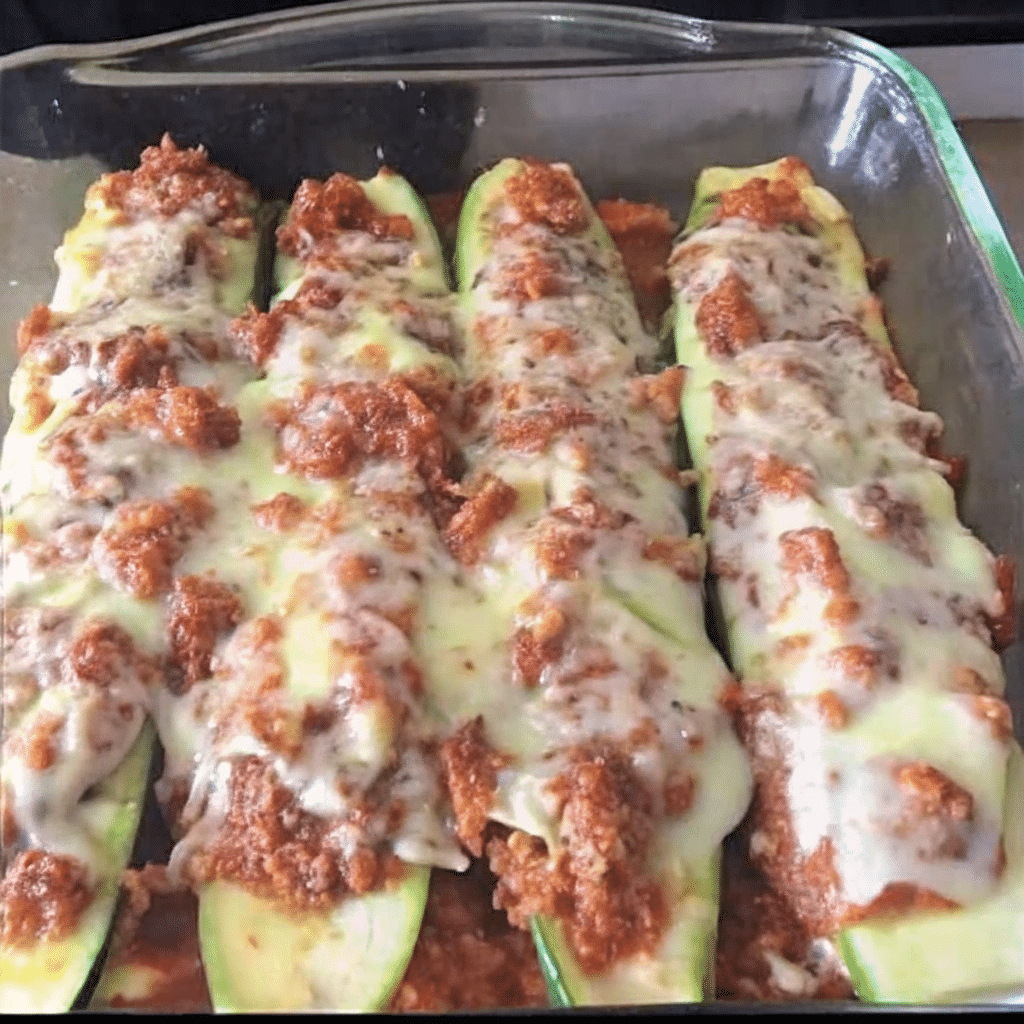 Golden-brown Mediterranean stuffed zucchini boats filled with seasoned ground lamb, feta cheese, pine nuts, and fresh mint, topped with breadcrumbs and melted mozzarella