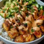 Colorful Bang Bang Chicken Bowl with golden seasoned chicken pieces, fresh vegetables, and creamy sauce served over white rice