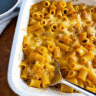 Creamy butternut squash mac and cheese in a white baking dish, topped with golden melted cheese and garnished with fresh chives