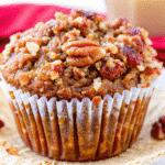 Golden-brown pumpkin pecan muffins with crunchy pecan topping arranged on a wire cooling rack, perfect for fall baking