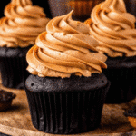 Rich chocolate pumpkin cupcakes topped with swirled pumpkin cream cheese frosting, garnished with a sprinkle of cinnamon