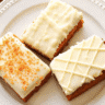 Perfectly moist pumpkin bars with cream cheese frosting, cut into squares and arranged on a wooden serving board