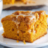 Golden pumpkin earthquake cake with swirled cream cheese, chocolate chips, and pecans showing characteristic cracked surface pattern in a white baking dish