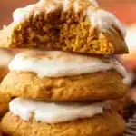 golden-brown soft pumpkin cookies with a tender, cake-like texture, arranged on a white plate with fall leaves in the background.golden-brown soft pumpkin cookies with a tender, cake-like texture, arranged on a white plate with fall leaves in the background.