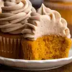 Moist pumpkin spice cupcakes with cream cheese frosting center, topped with perfectly piped cream cheese frosting swirls. The ultimate fall dessert that combines warm spices with creamy indulgence.