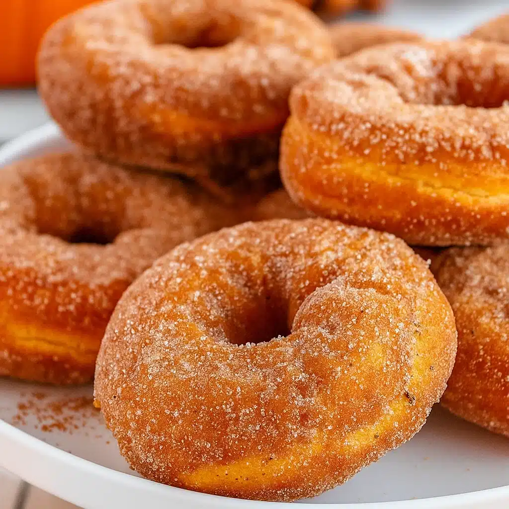 Golden-brown baked pumpkin donuts with glossy maple glaze arranged on a wire cooling rack