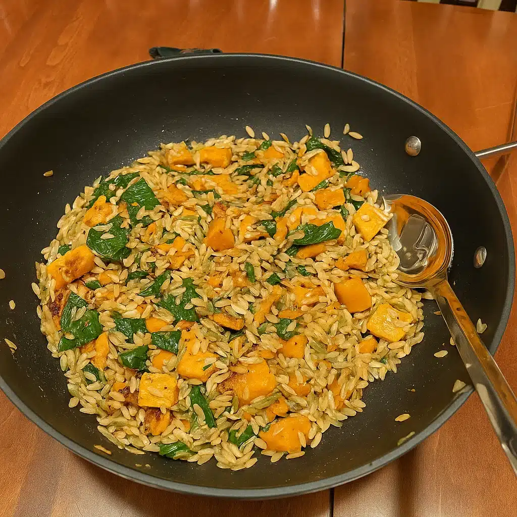 creamy orzo with roasted butternut squash and spinach topped with fresh thyme and grated cheese
