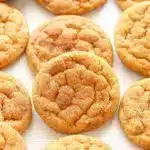 Soft and chewy pumpkin snickerdoodles with cinnamon sugar coating arranged on a white plate with fall decorations