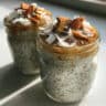 Creamy white coconut chia pudding in a glass bowl topped with fresh berries and toasted coconut flakes